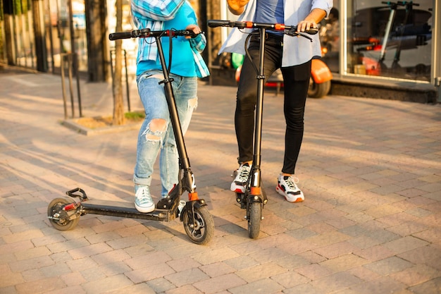 O casal apaixonado anda de patinete elétrico e olha um para o outro