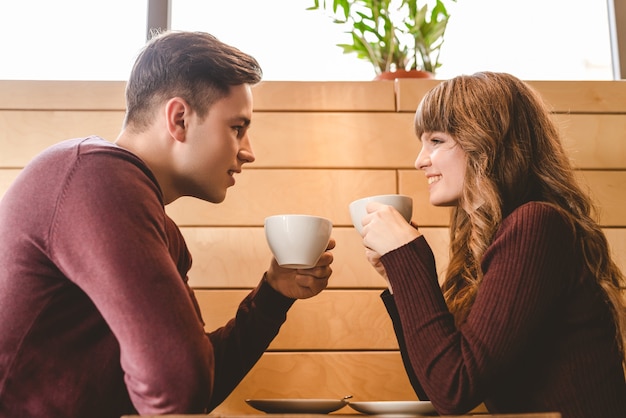 Foto o casal atraente tomando um café na mesa do café