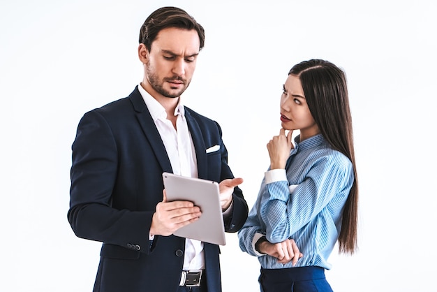 O casal de negócios com um tablet sobre um fundo branco