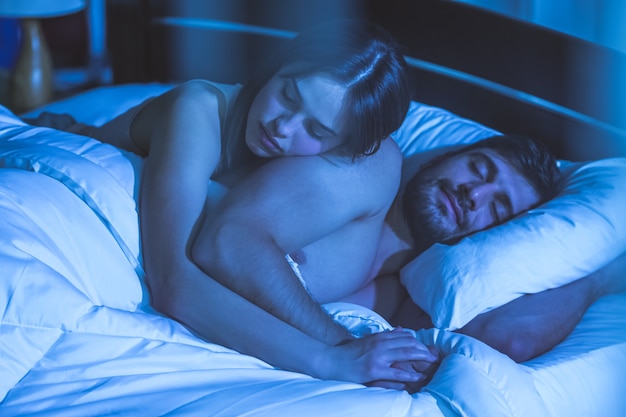 O casal dormindo na cama. período noturno