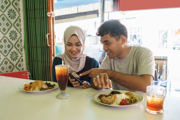 O casal está comendo comida tradicional