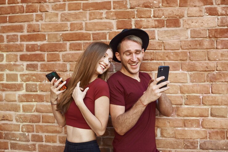 Foto o casal está usando o telefone. mulher e homem ficam de costas um para o outro, ao telefone.