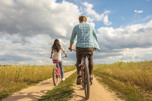 O casal feliz andando de bicicleta ao ar livre