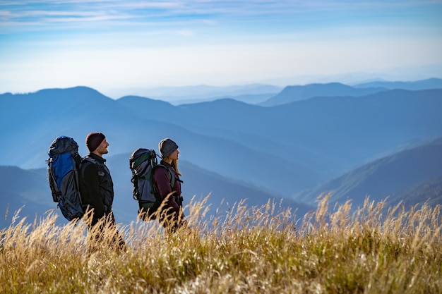 O casal feliz caminhando na montanha