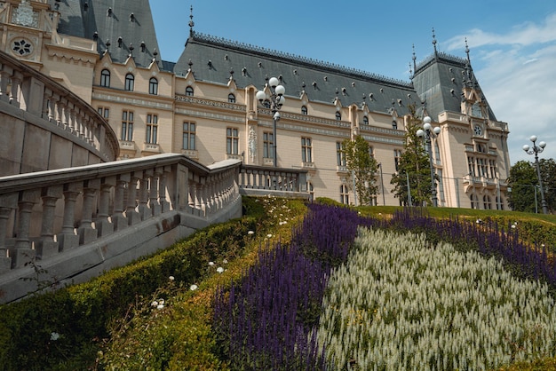 O castelo é cercado por flores e grama.