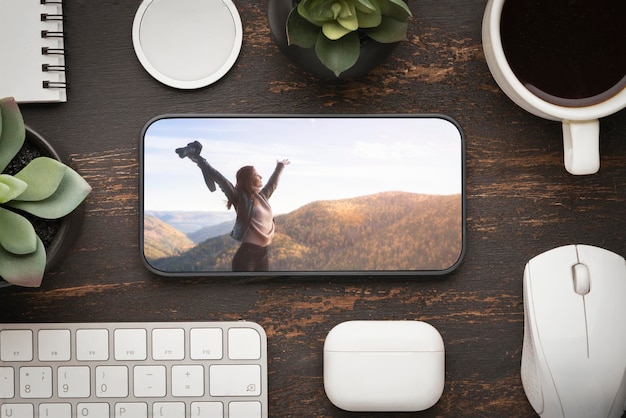 Foto o celular está sobre a mesa planejando uma viagem ou assistindo a um filme de fotos no local de trabalho em t