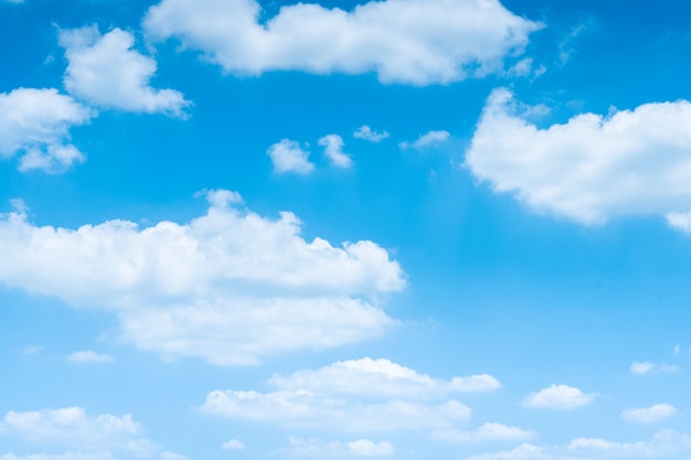 O céu azul com nuvens brancas em movimento.