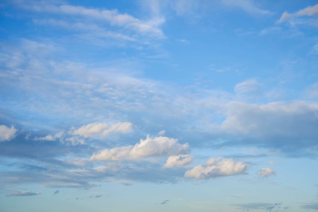 O céu está cheio de nuvens flutuando pequenas e grandes, o sol está brilhando