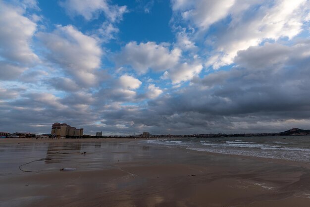 Foto o céu está coberto de nuvens escuras e a praia está nublada.