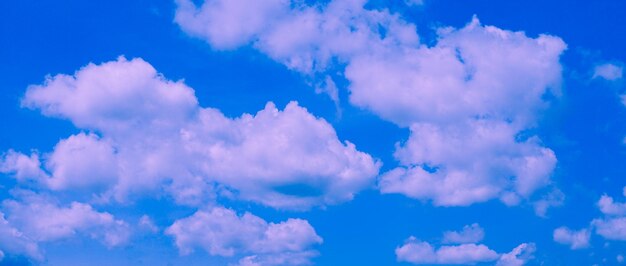 O céu pastel azul e as nuvens abstraem o fundo