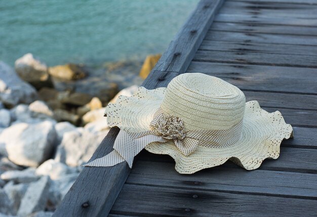 O chapéu é colocado em uma ponte de madeira à beira-mar.