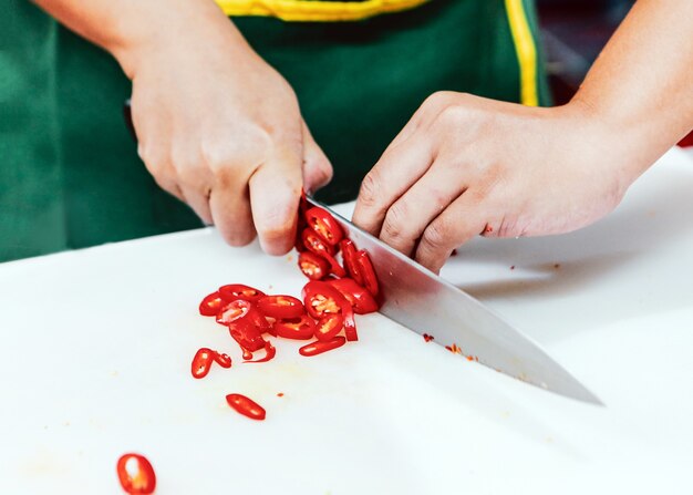 O chef corta vegetais na cozinha, o chef cozinha, o chef prepara a comida