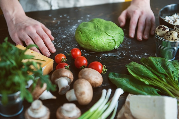 O chef cozinheiro, passo a passo, faz ravióli verde em forma de coração para um jantar festivo