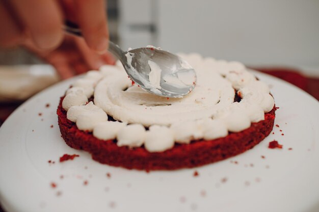 O chef de confeitaria faz um delicioso bolo de veludo vermelho. Cozinhando e decorando sobremesa