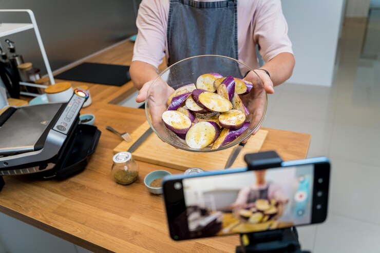 Foto o chef está a transmitir ao vivo da oficina como preparar uma berinjela grelhada com alho