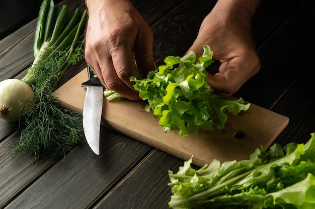 O chef está preparando uma salada na tábua da cozinha