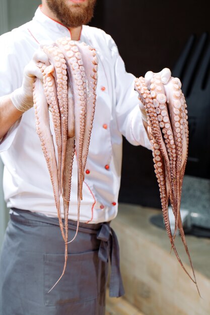 O chef está segurando um polvo.