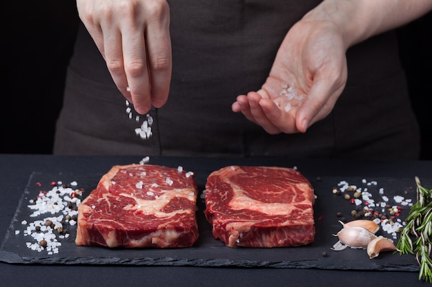 O chef mulher está a preparar um bife.