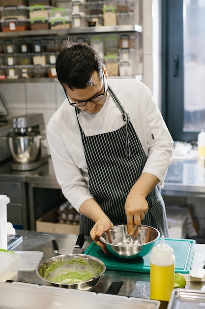 O chef prepara comida na moderna cozinha espaçosa