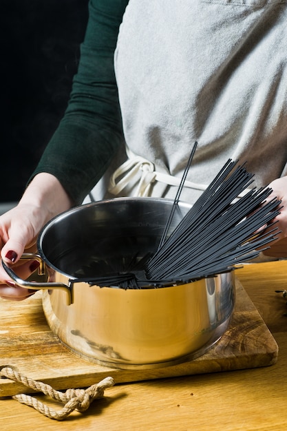 O chef prepara espaguete macarrão preto