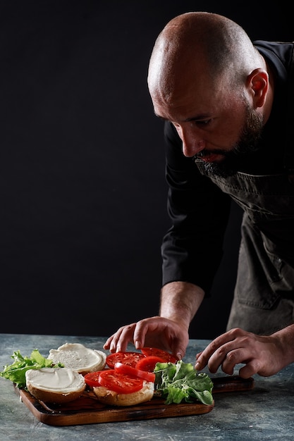 O chef prepara hambúrgueres no restaurante