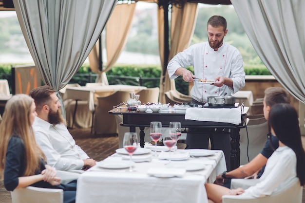 O chef prepara os foie gras diante dos convidados.