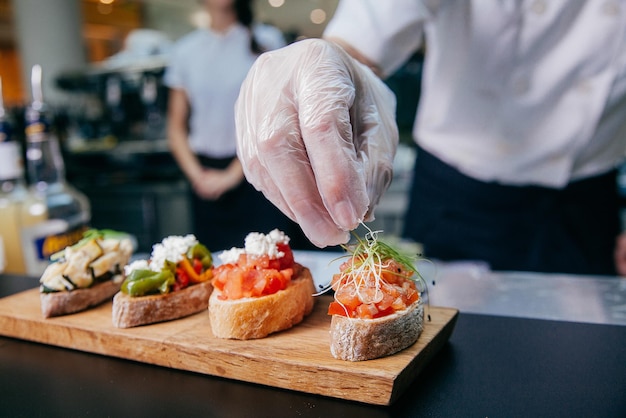 O chef prepara sanduíches de frutos do mar A mão e sanduíches