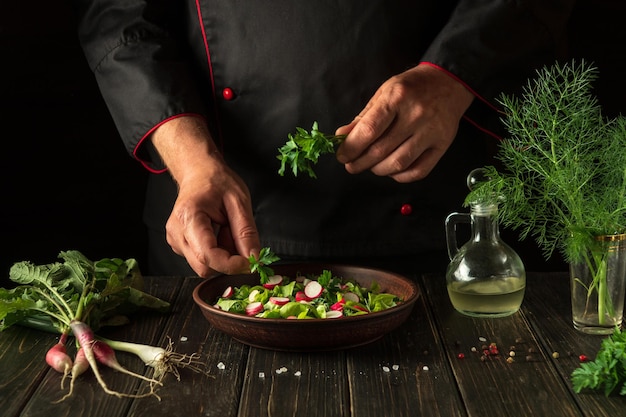 O chef prepara uma salada de legumes frescos A ideia de um café da manhã ou jantar dietético Cozinha vegetariana