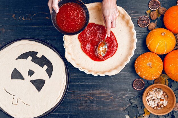 O chef prepara uma torta para o Halloween com recheio de geleia de abóbora e morango e pêssegos