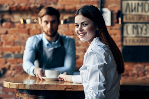 O chef serve ao cliente uma xícara de café com um prato na mesa e uma bebida de restaurante foto de alta qualidade