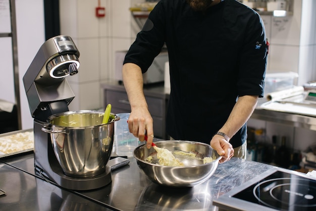 O chef trabalha na cozinha O processo de fazer massa para biscoitos