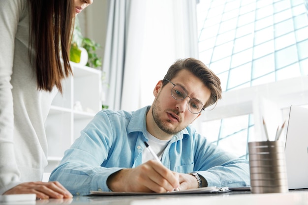 O chefe assina o documento chefe do departamento assinando documentos funcionários trabalhando em segundo plano