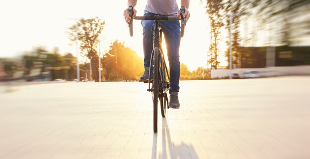 O ciclista com roupas casuais andando de bicicleta à noite