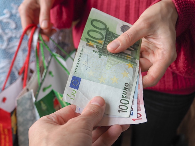 O cliente paga as notas de euro em dinheiro durante as compras. | Foto Premium
