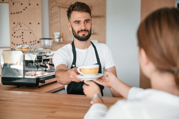 O cliente recebe seu pedido do barista no café