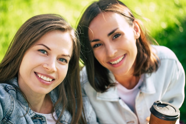 O clima legal em um ótimo dia. Feche a foto de selfie de duas lindas namoradas em roupas casuais ao ar livre