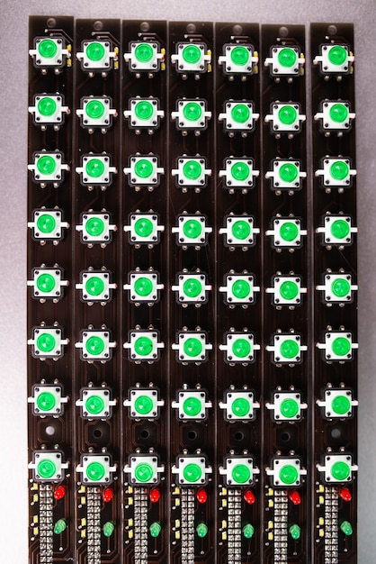 O close-up de um painel LED de indicadores de luz verde está em produção. O conceito de produção industrial de equipamentos para fins militares e estratégicos