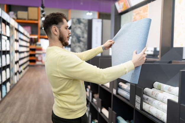 O comprador escolhe papel de parede de papel e vinil para reforma em seu apartamento