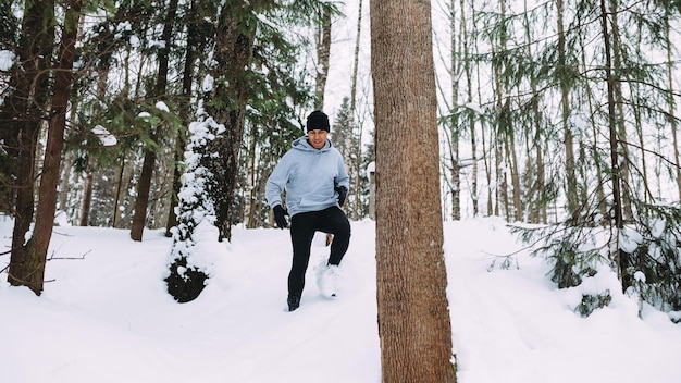 O comprimento total de um jovem correndo em um campo coberto de neve