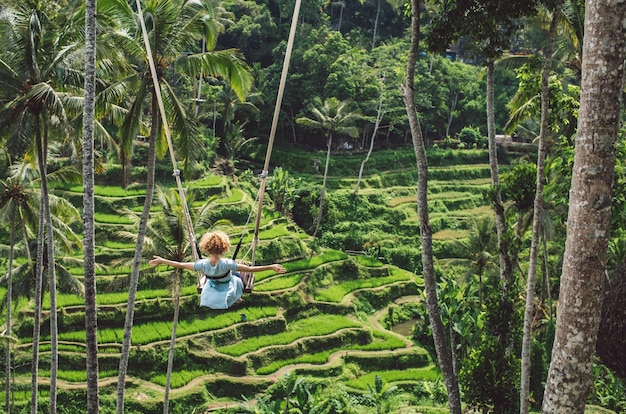 O comprimento total de uma mulher balançando na floresta