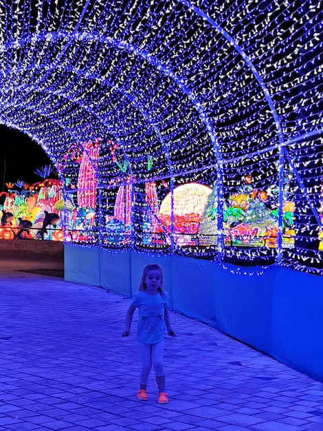 Foto o comprimento total de uma mulher de pé contra a luz iluminada