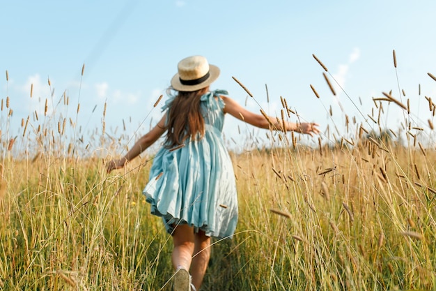 O comprimento total de uma mulher de pé no campo contra o céu