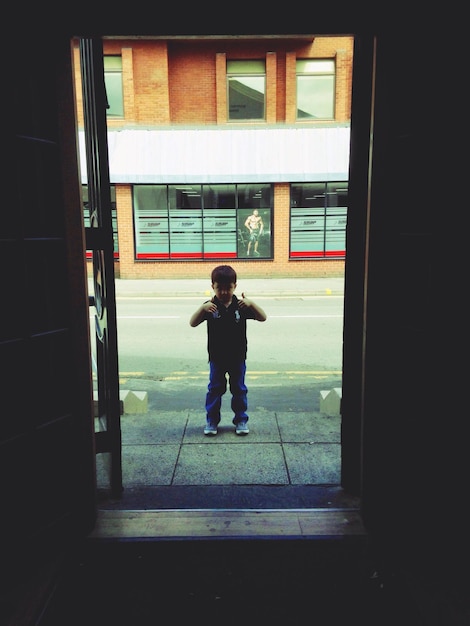O comprimento total do menino de pé na janela