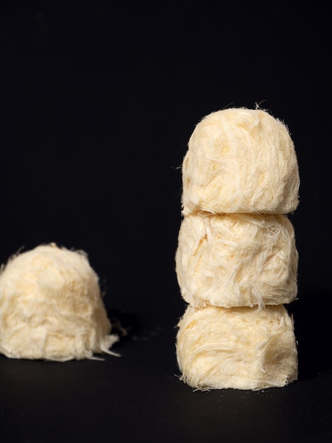 O conceito criativo doce de algodão doce pashmak fica em uma pirâmide em cima um do outro Fundo bege pastel