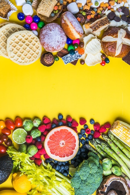 O conceito de comida saudável e insalubre Vista superior de frutas e legumes de fast-food e doces