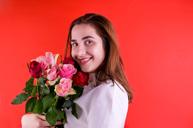 O conceito de dia dos namorados e dia da mulher. Jovem feliz, segurando um buquê de rosas