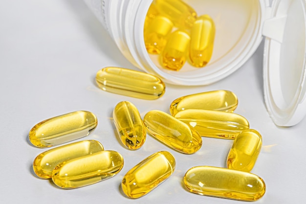 O conceito de dieta de nutrição saudável e suplementos omega3 closeup de cápsulas derramadas de um frasco