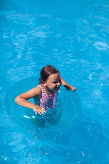 O conceito de férias de verão em que uma criança alegre se diverte nas águas límpidas e transparentes do ...