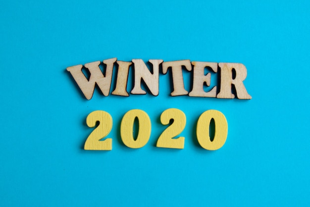 O conceito de inverno no ano novo. Números de madeira 2020 com letras