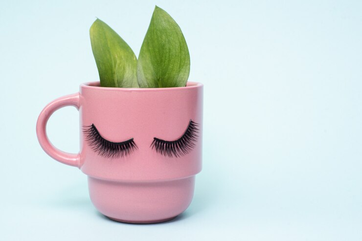 Foto o conceito de manhã feminina e café natural. rosa caneca de café da manhã com orelhas como um coelho de folhas verdes. copyspace